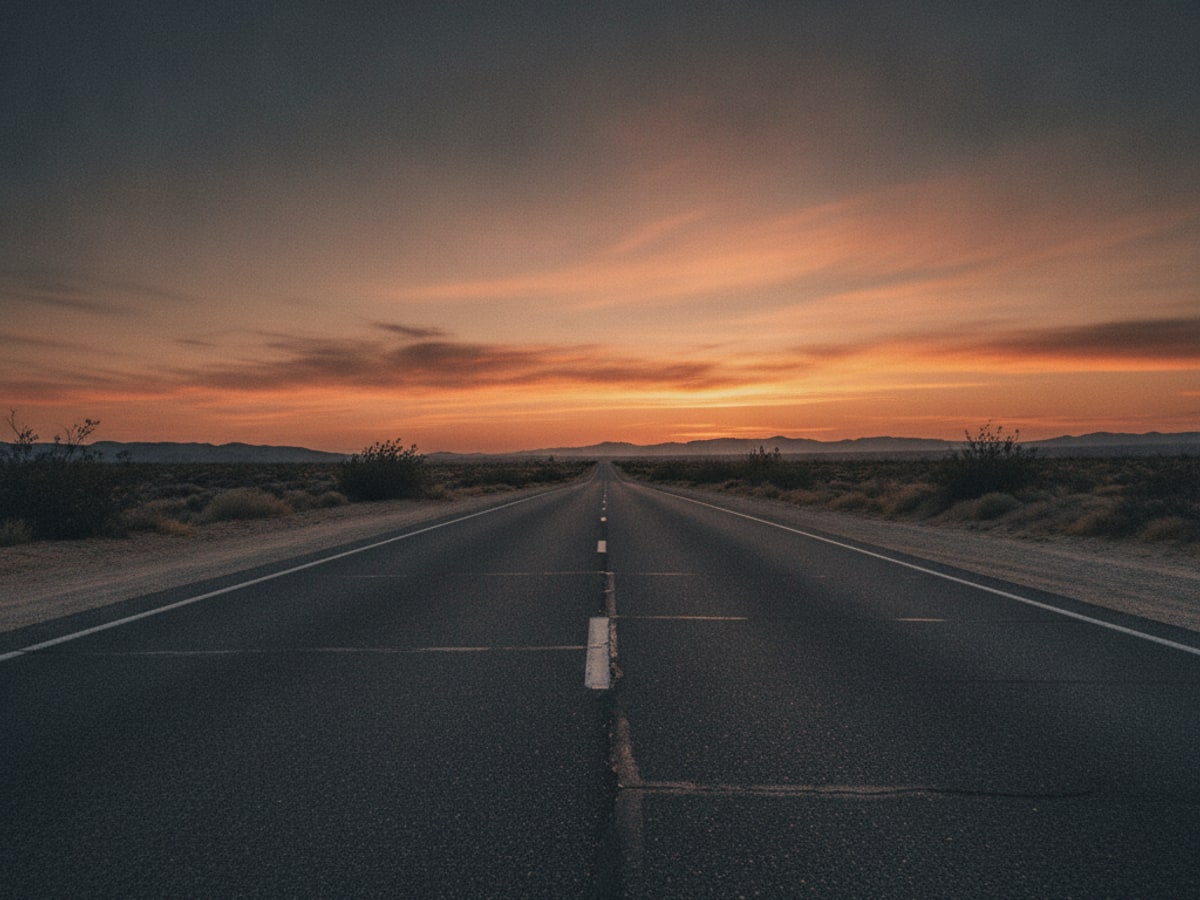 An empty highway at dusk stretching toward the horizon