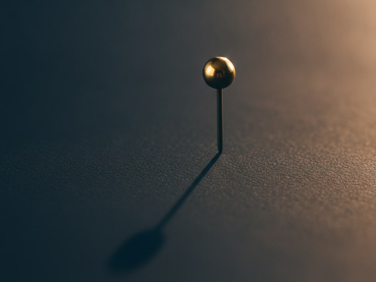 A map pin casting a long shadow across a plain surface