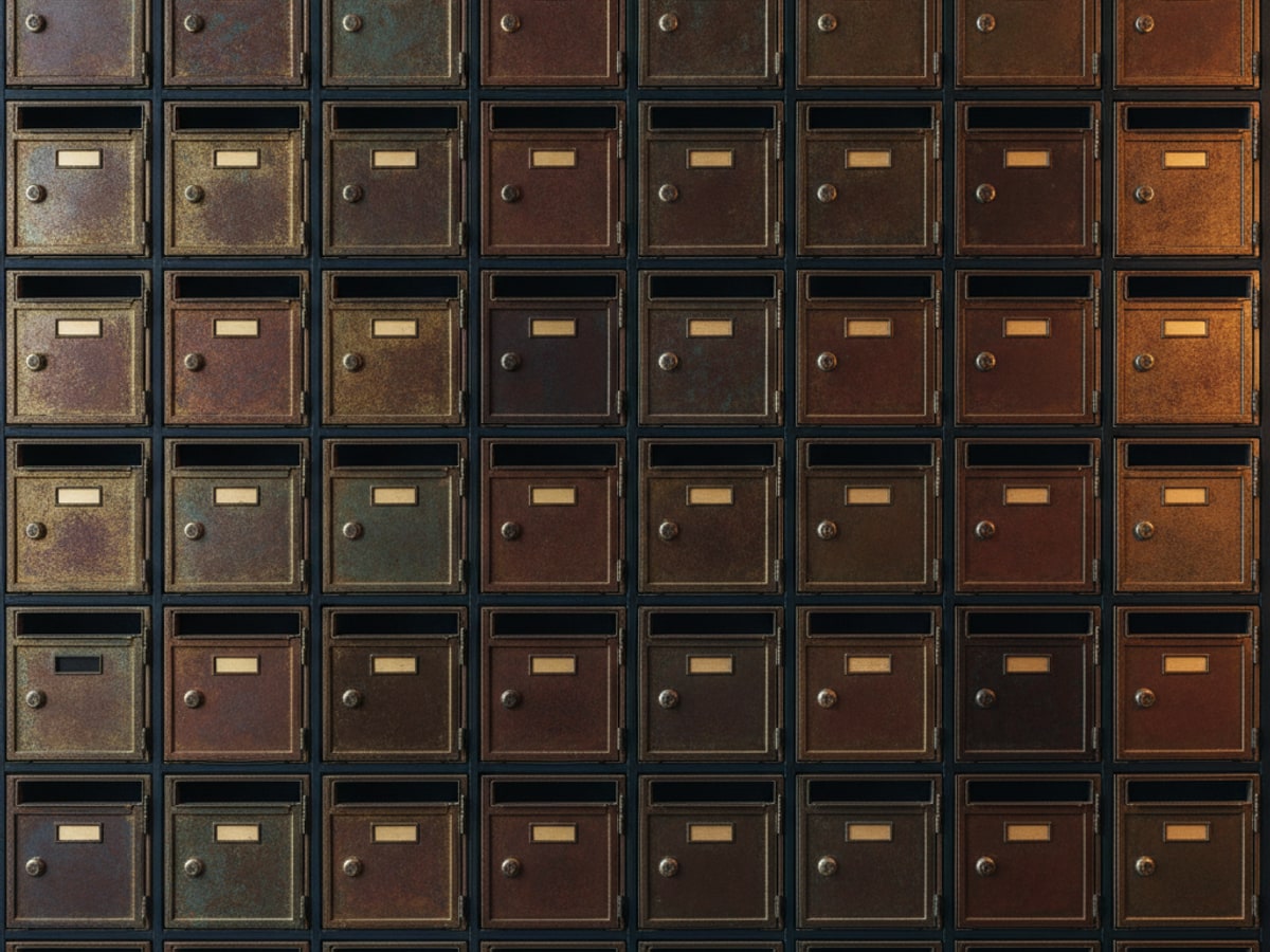 A wall of small numbered brass mailboxes, each slightly different
